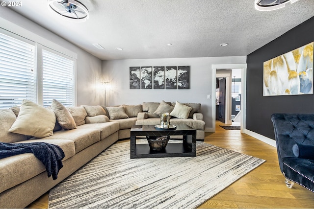 living room featuring wood-type flooring and a textured ceiling