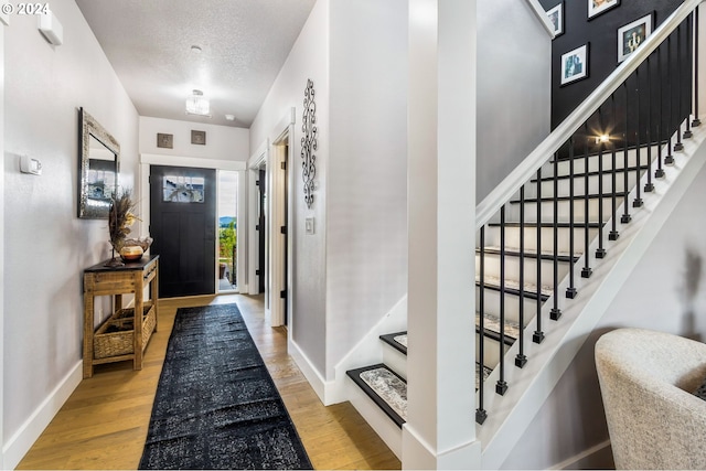 entrance foyer with hardwood / wood-style floors and a textured ceiling