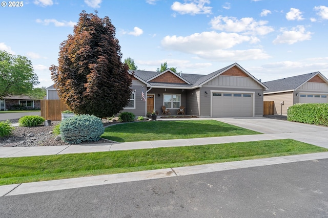 view of front of house featuring a front yard, fence, driveway, a garage, and board and batten siding