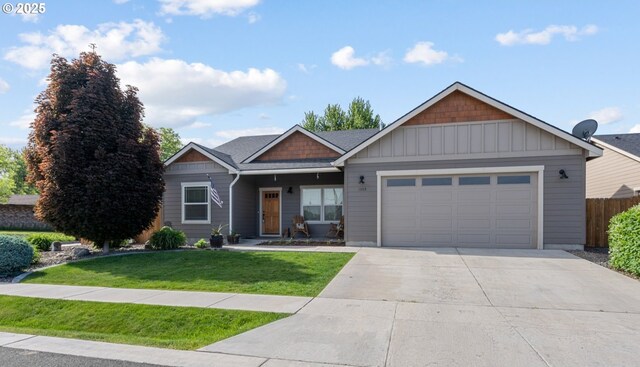 view of front of house featuring a front yard, fence, driveway, a garage, and board and batten siding