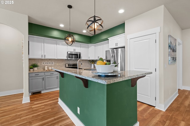 kitchen featuring decorative backsplash, a kitchen breakfast bar, and stainless steel appliances