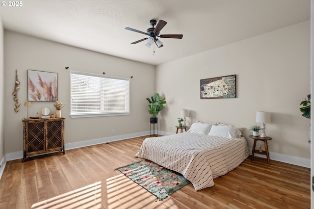 bedroom with baseboards, wood finished floors, and a ceiling fan