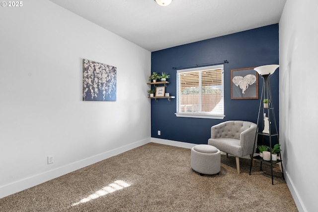 living area featuring carpet and baseboards