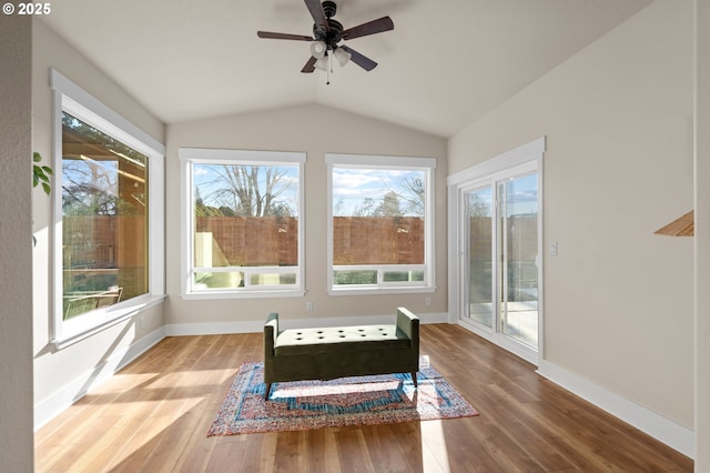 living area featuring hardwood / wood-style floors, vaulted ceiling, a ceiling fan, and baseboards