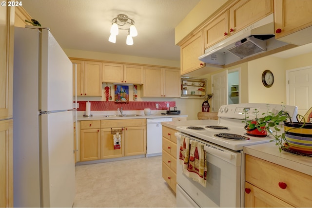 kitchen with light brown cabinets, white appliances, and sink