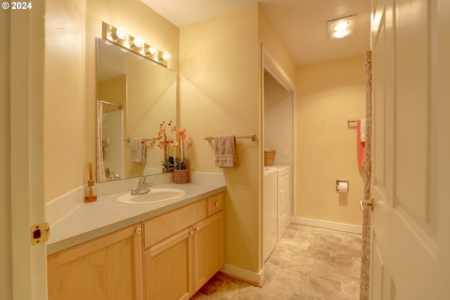 bathroom with independent washer and dryer and vanity