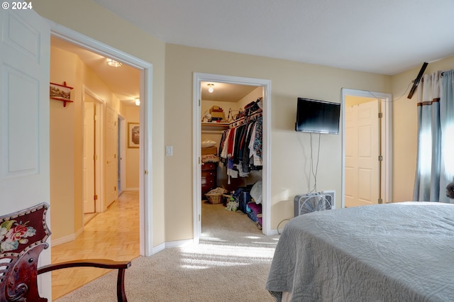 bedroom featuring a spacious closet, a closet, and light parquet flooring