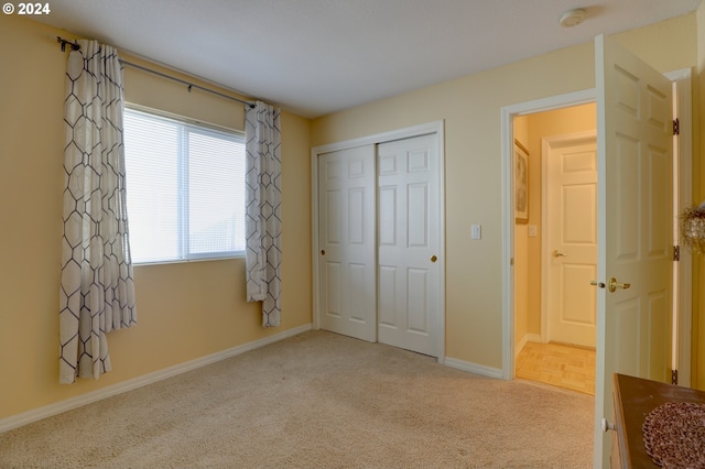 unfurnished bedroom with light colored carpet and a closet