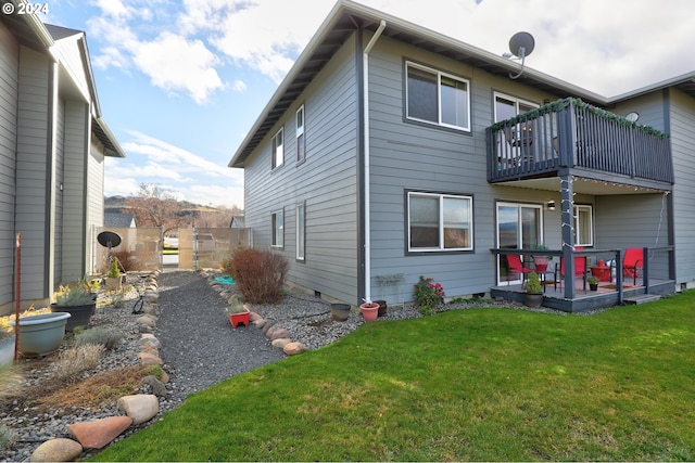 rear view of property with a lawn and a balcony