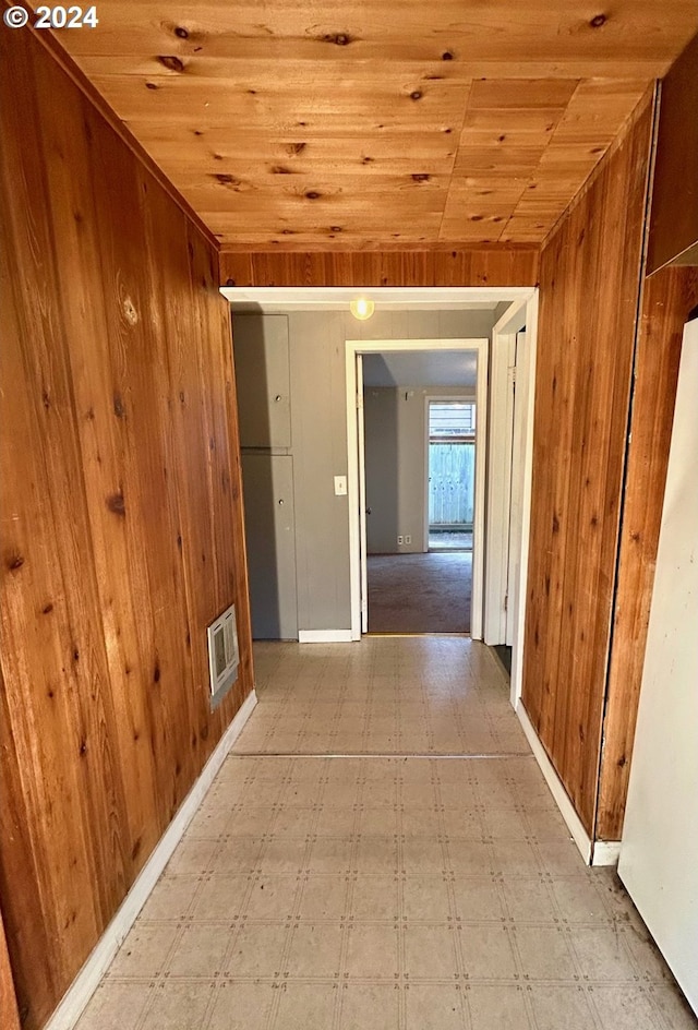 hall featuring wood ceiling and wood walls