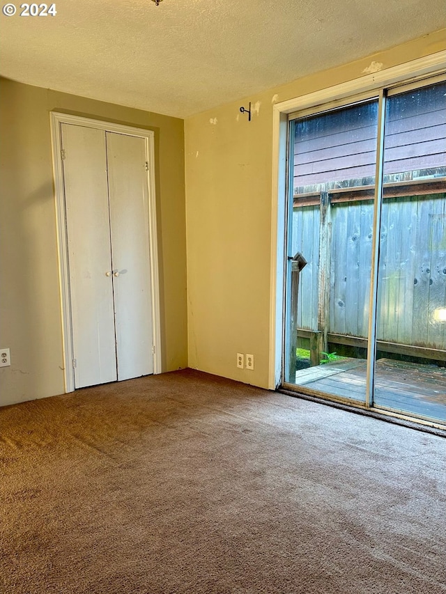 unfurnished bedroom with a textured ceiling and carpet flooring