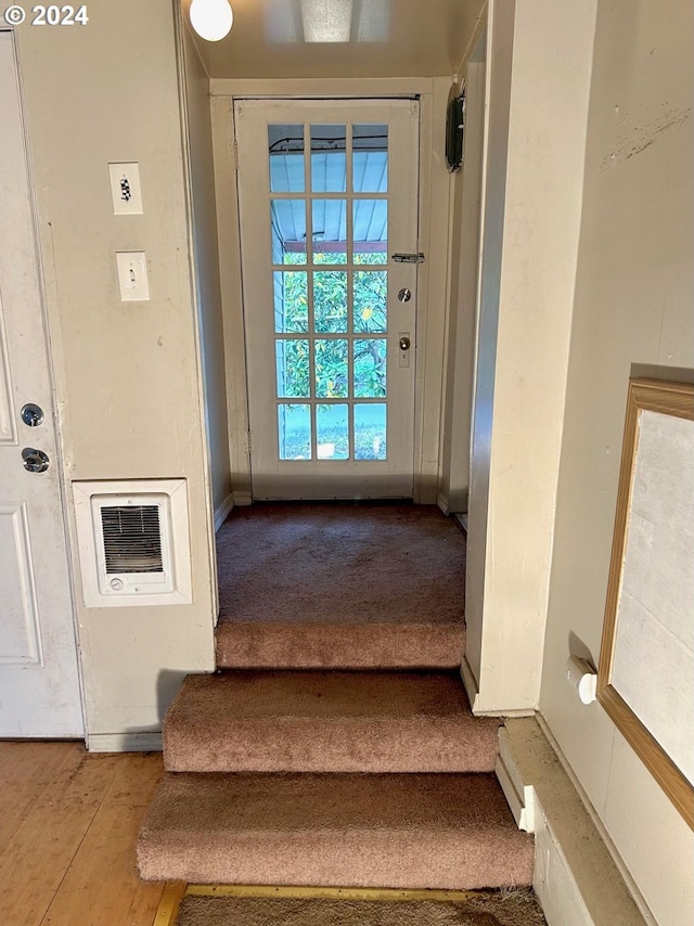 stairs with wood-type flooring and heating unit