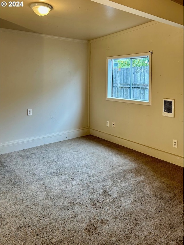 carpeted spare room featuring heating unit, baseboards, and ornamental molding