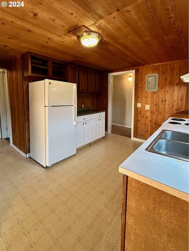 kitchen with wood walls, sink, wood ceiling, and white refrigerator