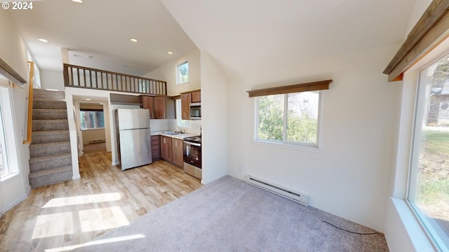 kitchen with baseboard heating, appliances with stainless steel finishes, light hardwood / wood-style flooring, and sink