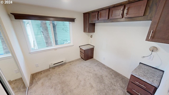 kitchen with a baseboard radiator, light colored carpet, and dark brown cabinets