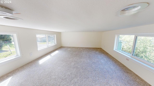 carpeted spare room featuring a textured ceiling