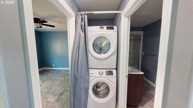 washroom featuring stacked washer / dryer, light wood-type flooring, and ceiling fan