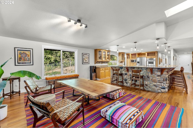 living room featuring light wood-type flooring, a textured ceiling, and a skylight