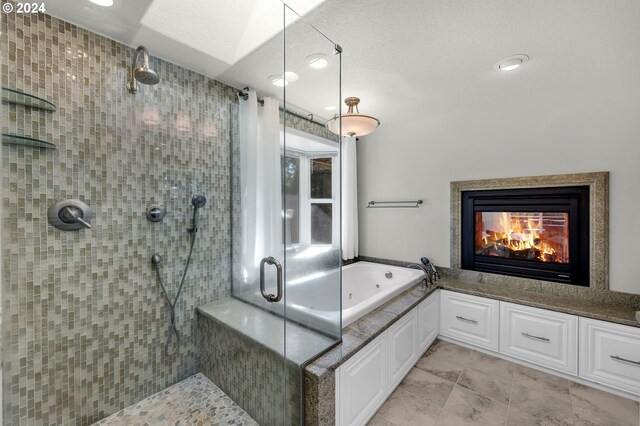 bathroom featuring a textured ceiling, shower with separate bathtub, vanity, and a multi sided fireplace