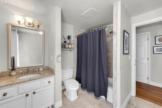 full bathroom featuring shower / bathtub combination with curtain, toilet, wood-type flooring, vanity, and a textured ceiling