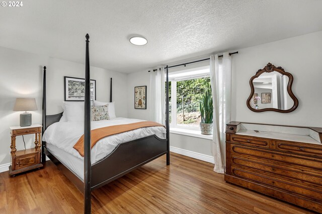 bedroom with hardwood / wood-style flooring and a textured ceiling