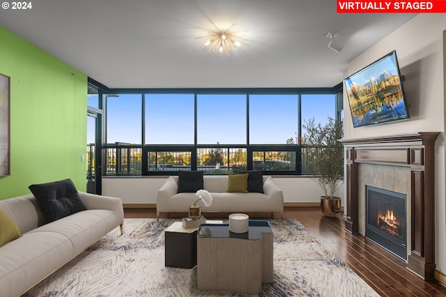 living room with a tiled fireplace and hardwood / wood-style floors