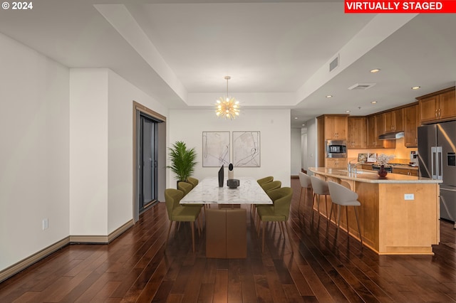 dining area featuring an inviting chandelier, sink, and dark hardwood / wood-style flooring