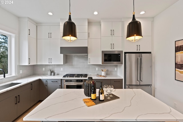 kitchen featuring pendant lighting, white cabinetry, appliances with stainless steel finishes, and sink