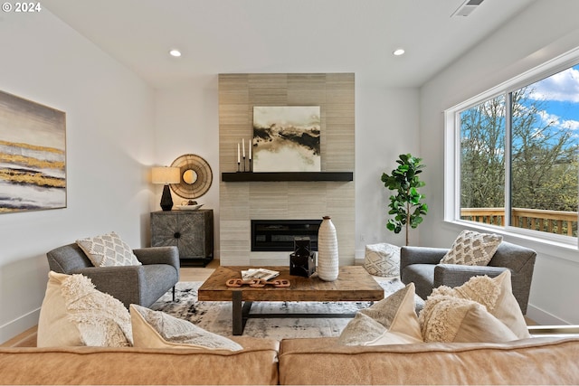 living room featuring hardwood / wood-style floors and a tiled fireplace