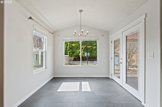 unfurnished dining area with lofted ceiling, a notable chandelier, baseboards, and a textured ceiling