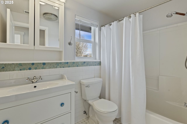 bathroom featuring visible vents, tile walls, toilet, wainscoting, and vanity