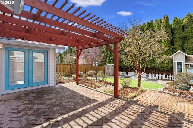 view of patio featuring a fenced backyard, a pergola, and french doors