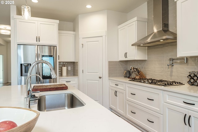 kitchen featuring white cabinetry, appliances with stainless steel finishes, and wall chimney exhaust hood