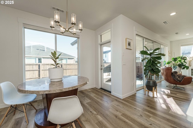 dining space with a chandelier and light wood-type flooring