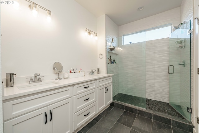 bathroom with a shower with door, vanity, and tile patterned flooring