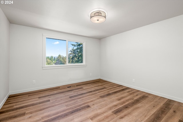 unfurnished room with wood-type flooring