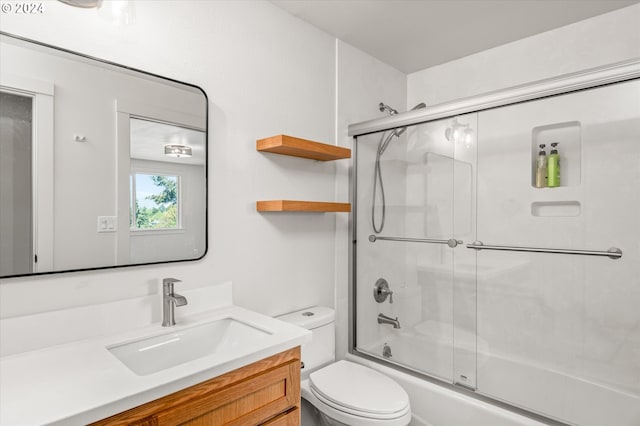 full bathroom with vanity, shower / bath combination with glass door, and toilet