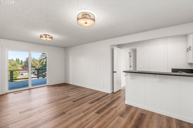 unfurnished living room with hardwood / wood-style floors and a textured ceiling