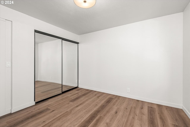 unfurnished bedroom with light hardwood / wood-style floors and a closet