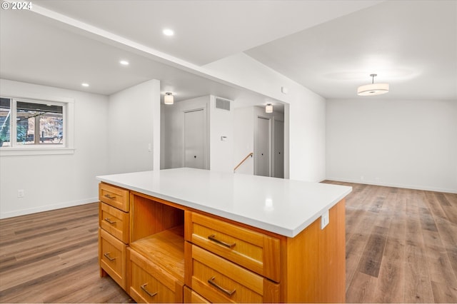 kitchen with hardwood / wood-style floors, decorative light fixtures, and a center island