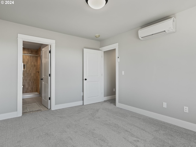 unfurnished bedroom with carpet flooring, a wall mounted AC, connected bathroom, and baseboards