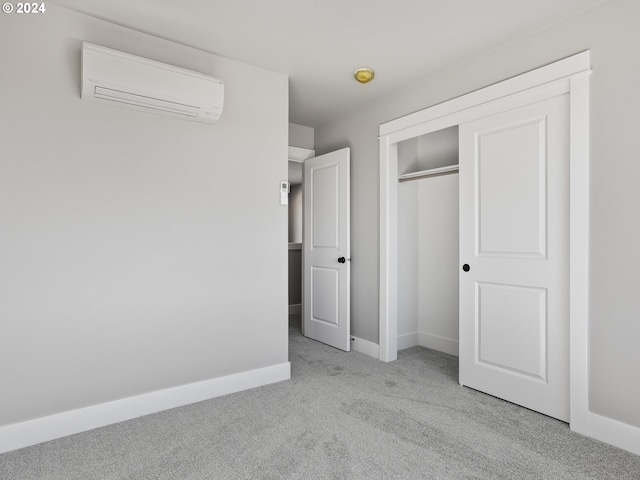 unfurnished bedroom with light carpet, baseboards, a closet, and a wall unit AC