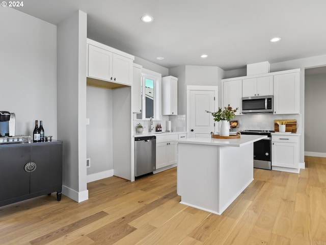 kitchen with white cabinetry, light countertops, light wood-type flooring, and appliances with stainless steel finishes