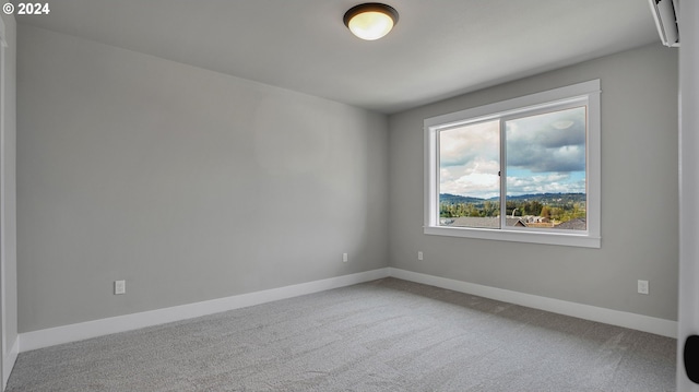 carpeted empty room featuring baseboards