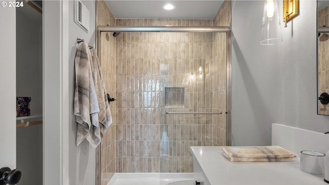 bathroom featuring toilet, a shower with shower door, vanity, and tile patterned floors