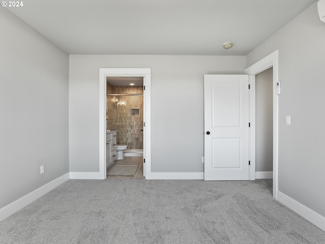 unfurnished bedroom featuring baseboards, ensuite bath, an AC wall unit, and carpet