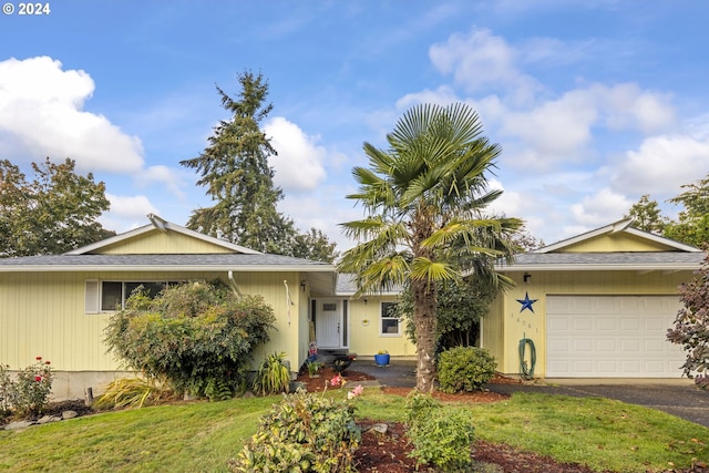 ranch-style home with a garage and a front lawn