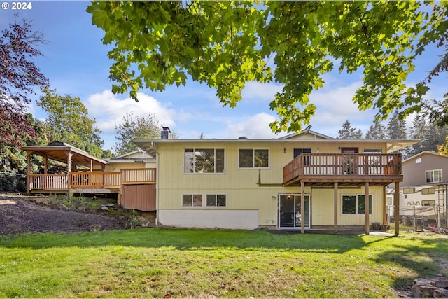 back of property featuring a gazebo, a deck, and a lawn