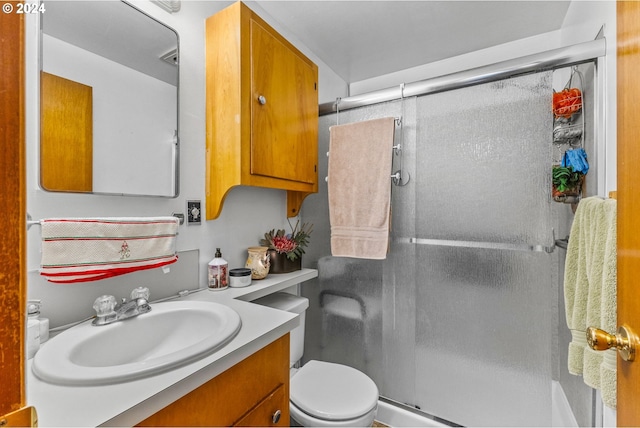 bathroom with an enclosed shower, vanity, and toilet